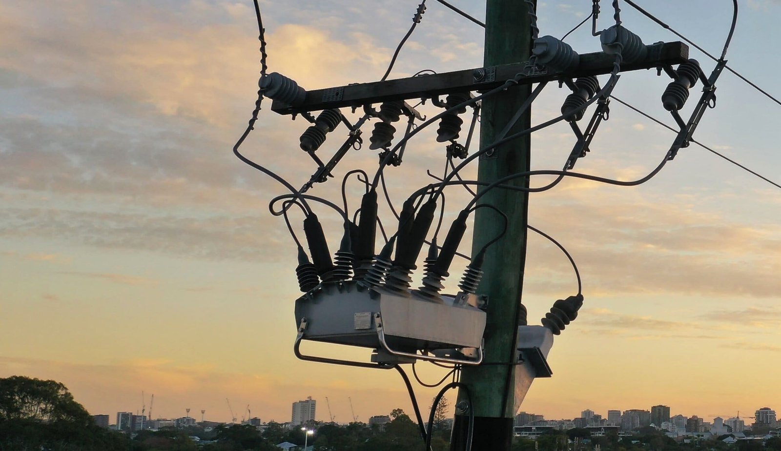 Pole-mounted recloser on a medium-voltage feeder at sunset.